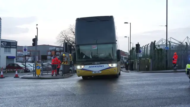 A bus drives out of a carpark.