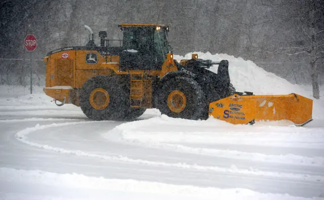 Snow plough moving heaps of snow.