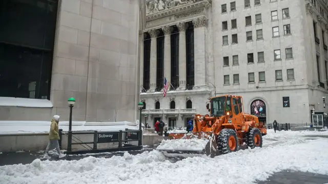 A bulldozer clears snow near the New York Stock Exchange on Wall Street
