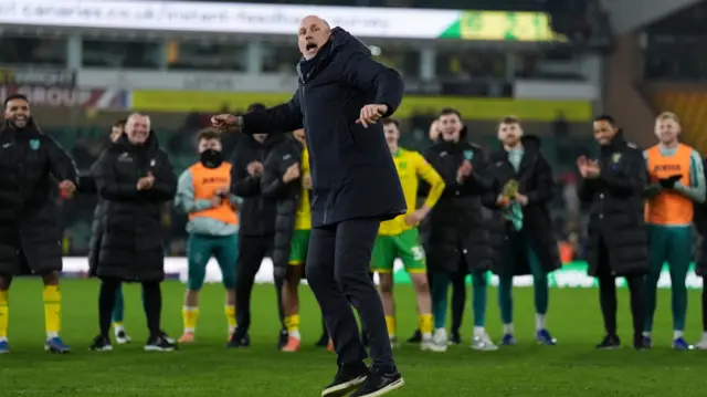 Philippe Clement celebrates in front of the Norwich fans with his players standing behind him in a line and applauding