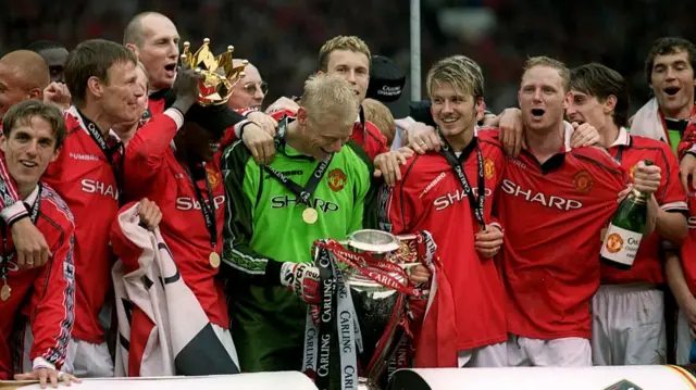 Peter Schmeichel holding the Premier League trophy with his Manchester United team-mates