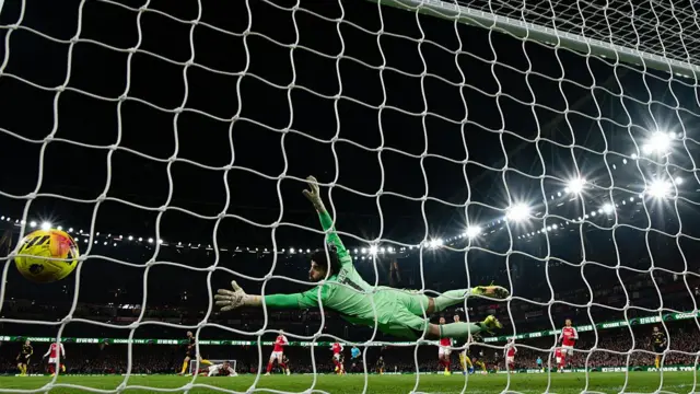 Arsenal goalkeeper David Raya dives in vain as Matheus Cunha's matching-winning shot flies into his net