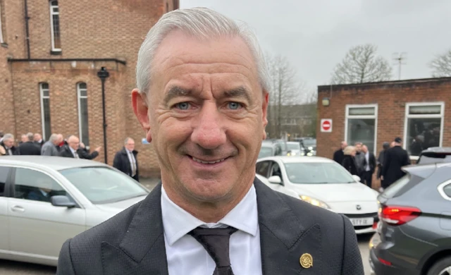 Ian Rush outside the church wearing a black and white suit.