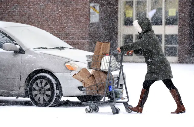 A woman braves the snow to get supplies in Bridgeport, Connecticut, on Sunday