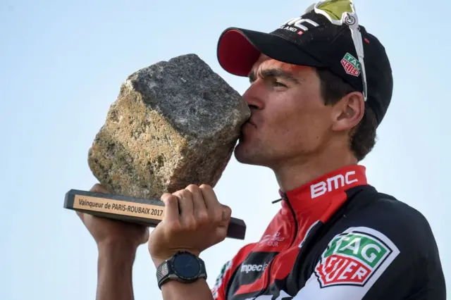 Belgium's Greg Van Avermaet kisses his trophy as he celebrates on the podium after winning the 115th edition of the Paris-Roubaix one-day classic cycling race, between Compiegne and Roubaix, on April 9, 2017 in Roubaix, northern France.