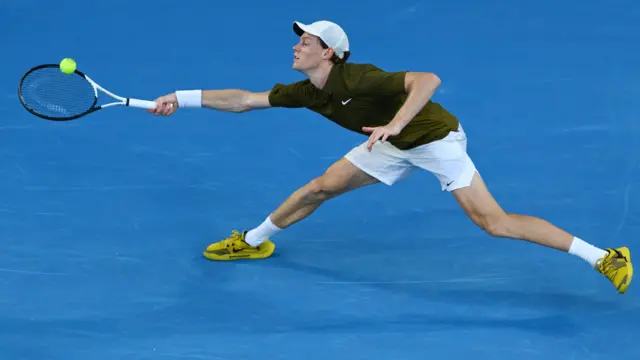 Jannik Sinner stretches to reach a forehand