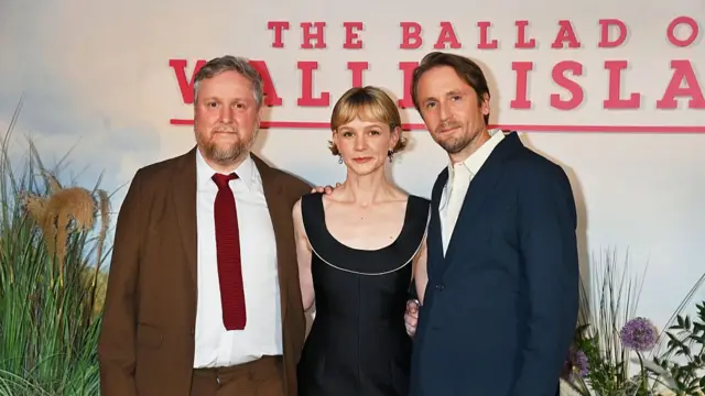Tim Key, Carey Mulligan and Tom Basden pose in front of a backdrop reading Ballad of Wallis Island