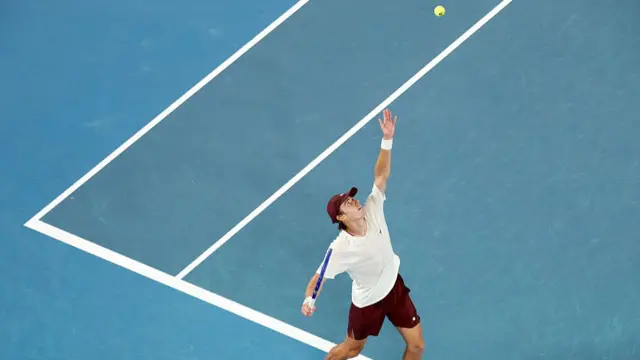 Alex De Minaur serves