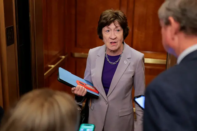 Maine Senator Susan Collins holds a folder while speaking with reporters