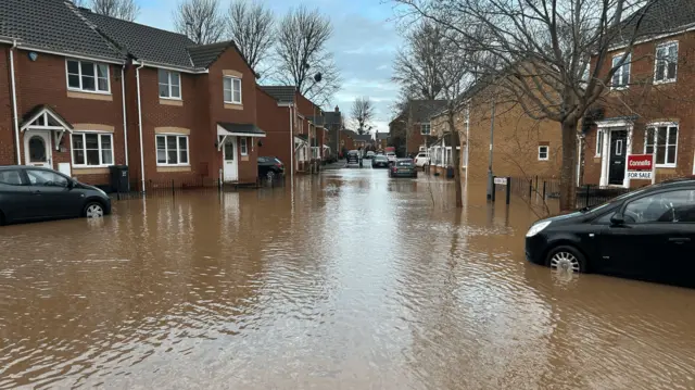 Severn Drive in Taunton. Floodwater is across the road and up to the front doors of homes.