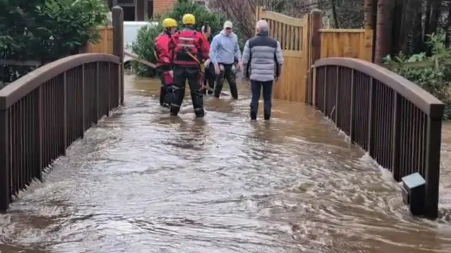 Flooded bridge with firefighters