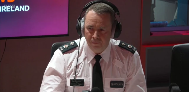 Sam Donaldson in Policing uniform in studio with headphones on.