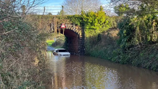 Car stuck in floodwater under railway bridge on Vaughan Road in Exeter