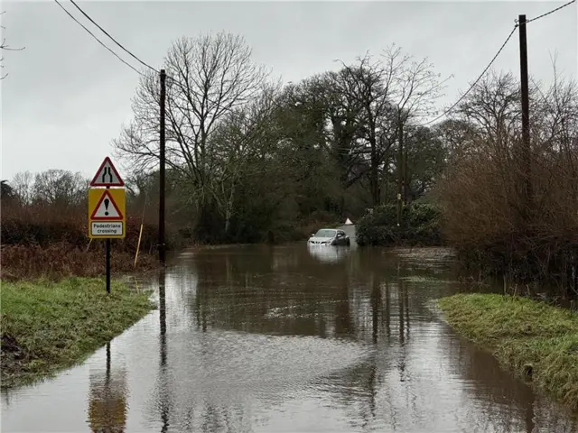 Crow hill in Ringwood under water. A car is seen struggling through the water.