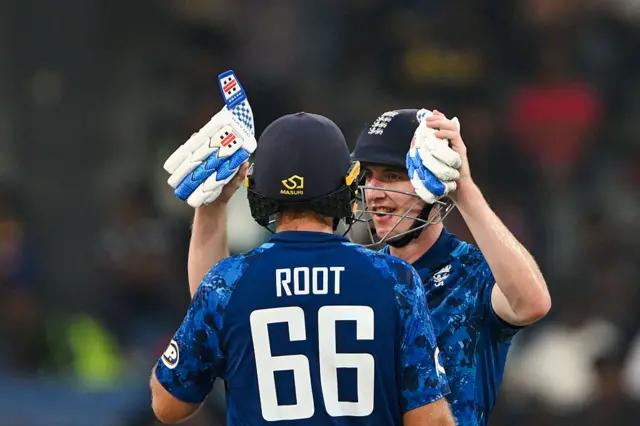 Harry Brook and Joe Root celebrate the former's century with an embrace