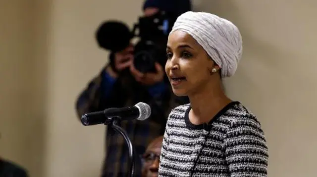 Rep Ilhan Omar in a white head scarf and striped top