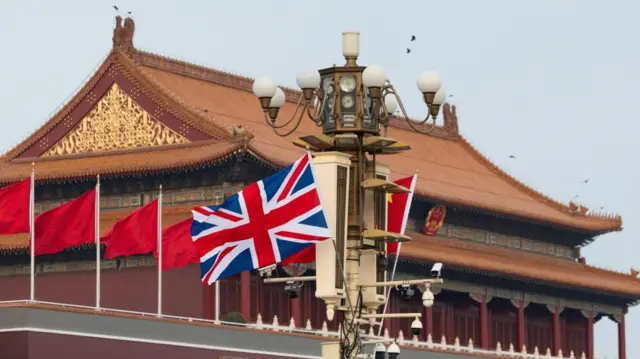 The National flag of China and the British Union Jack flutter next to the Tiananmen Gate