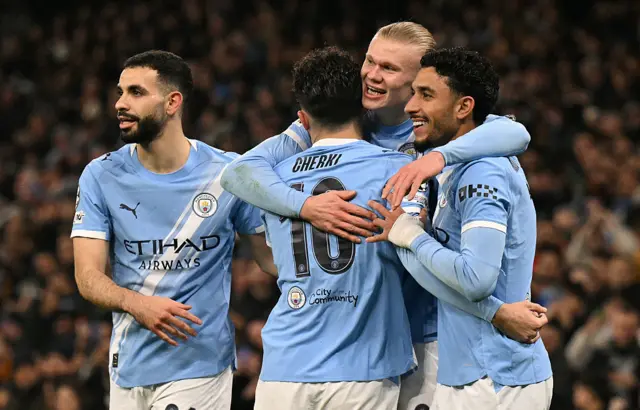 Manchester City's Norwegian striker #09 Erling Haaland (2R) is mobbed by teammates after scoring the opening goal