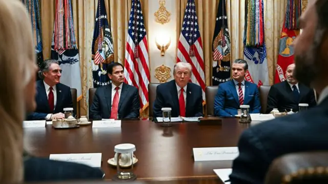 Donald Trump sits between officials in his cabinet room