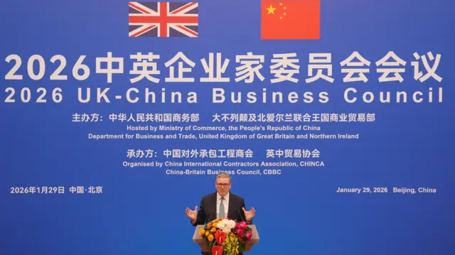 Keir Starmer in front of a podium and against a blue background
