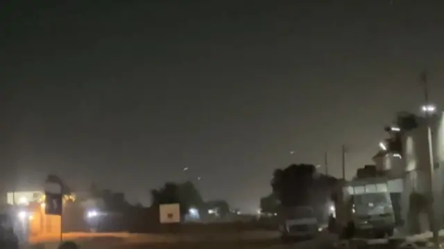 A screengrab from one of the videos taken outside the airport where lights can be seen illuminating the night sky