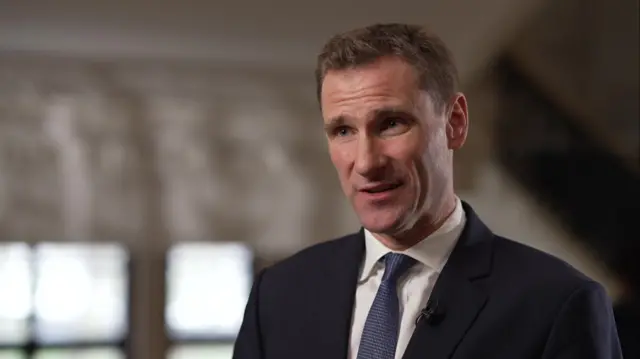 Chris Philip wearing a blue suit