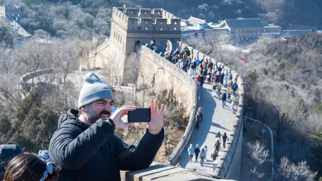 Tourist taking picture on top of the Great Wall of China
