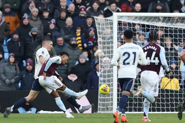 Aston Villa's English striker #11 Ollie Watkins (2L) shoots to score the opening goal