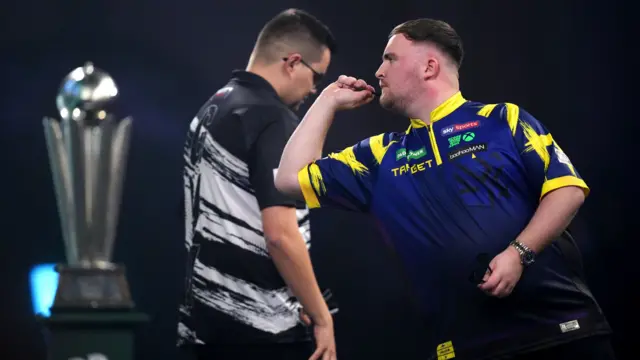 Luke Littler throws a dart