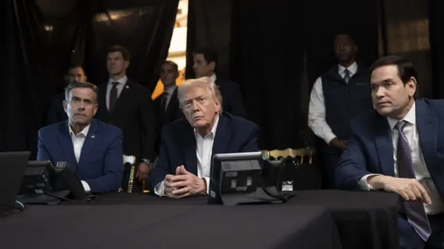 Trump sits at the centre of the table with his hands together. Rubio sits to his left