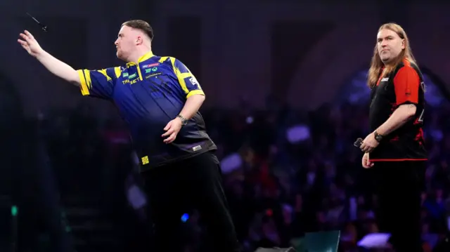 Luke Littler throws a dart