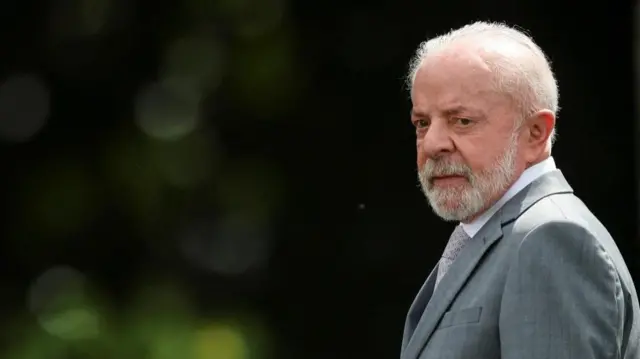 Lula in a grey suit standing in an outdoor space