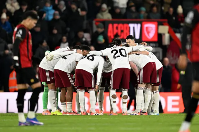 Arsenal players have a team huddle prior to the second half