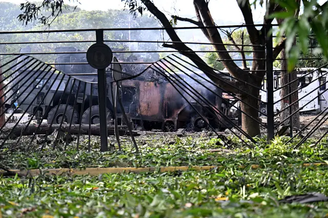 A burnt missile interceptor vehicle is seen behind railings at La Carlota air base in Caracas