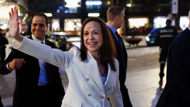Maria Corina Machado waves to supporters as she walks in Oslo