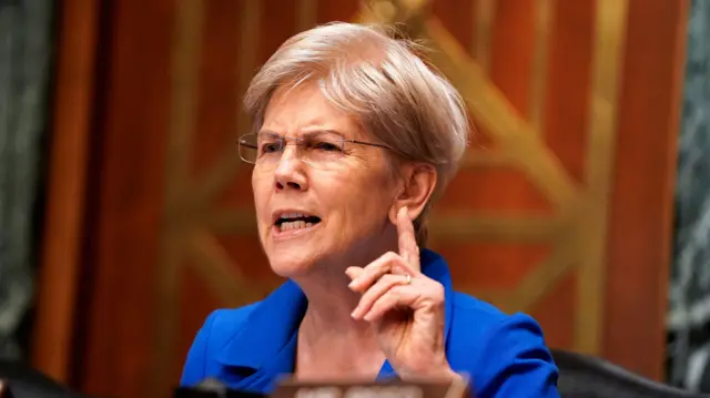 Democratic Senator Elizabeth Warren with her finger pointing upwards and her mouth partly open. She is speaking at a Senate Banking, Housing and Urban Affairs Committee nomination hearing on Capitol Hill in Washington