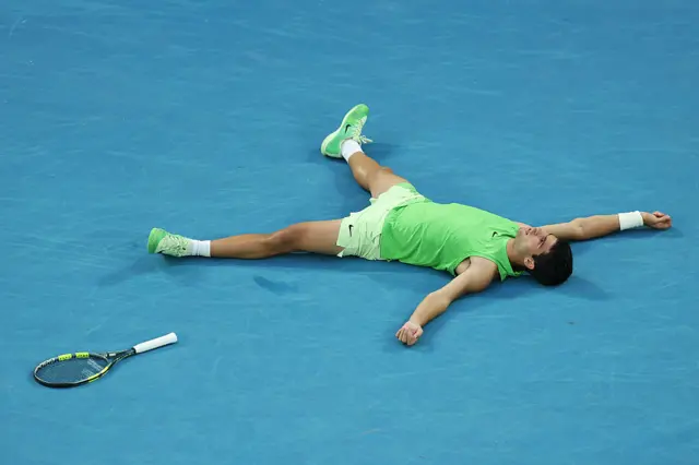 Carlos Alcaraz lies on the ground