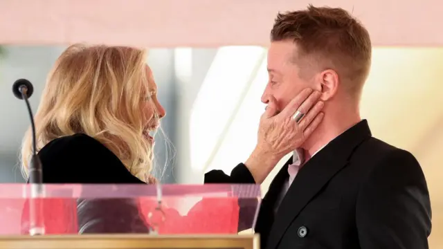 Catherine O’Hara holds Macaulay Culkin's face as the pair attend the unveiling ceremony of Culkin's star on the Hollywood Walk of Fame, in Los Angeles