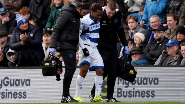 Karamoko Dembele is helped off the Loftus Road pitch with an injury
