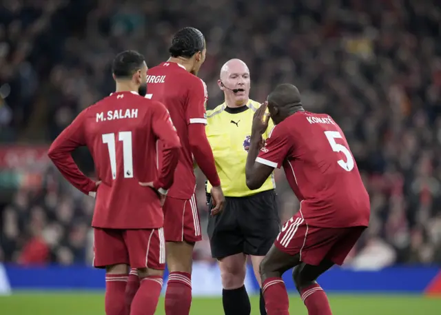 Liverpool players surround the referee