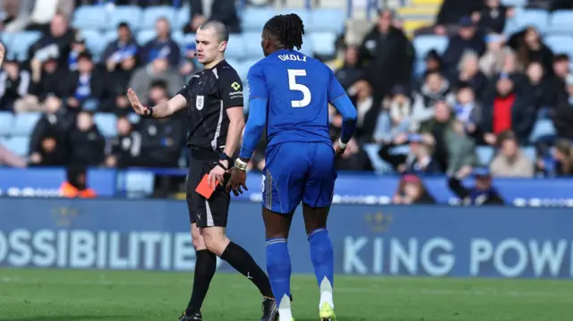 Caleb Okoli is shown a red card