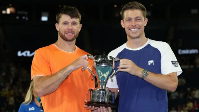 Christian Harrison and Neal Skupski hold the men's doubles trophy