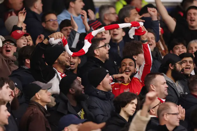 Arsenal fans waves a red and white scarf in the away end