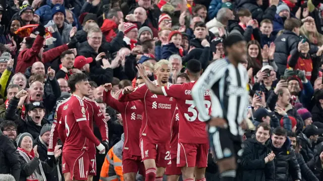 Livrpool players crowd Ekitike as Newcastle players trudge back to kick off