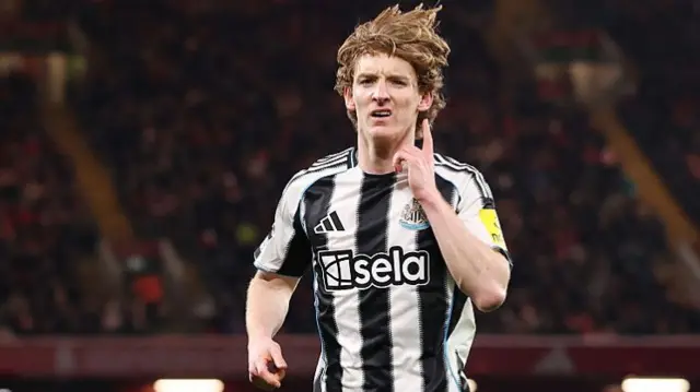 Gordon points to his ear as the home fans boo his goal for Newcastle