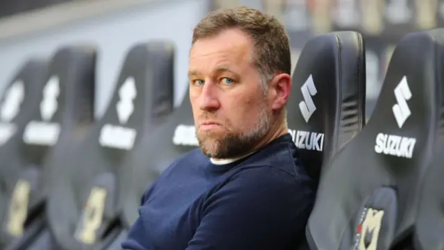 An unsmiling Grimsby manager David Artell sitting pitchside