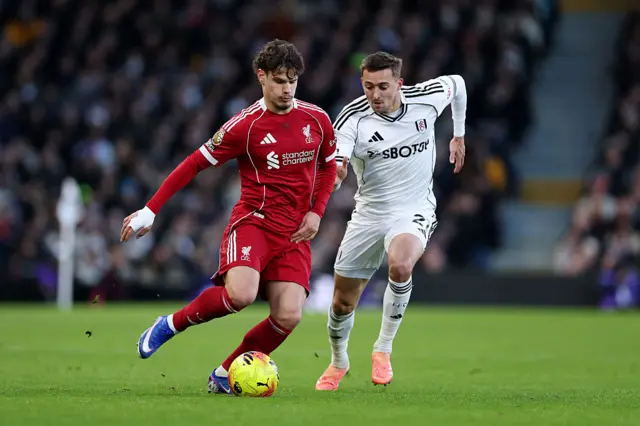 Milos Kerkez of Liverpool is challenged by Timothy Castagne of Fulham