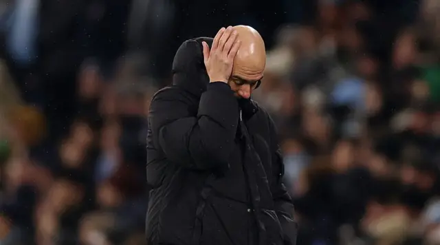 Pep Guardiola puts his hand on his head.