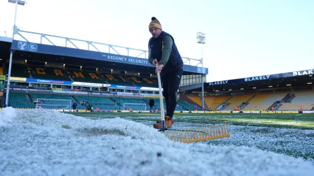 Groundsman clears the pitch of snow at Carrow Road