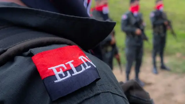 A close up of someone's shoulder, they're wearing a canvas coat with a patch sewn on showing the ELN logo.
